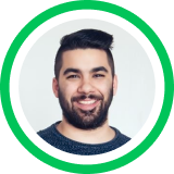 Headshot portrait of a smiling person with dark beard against gray background in circular green frame